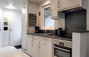 a kitchen with white cabinets and a sink and a window at Stunning Home In Vorden With Wifi in Vorden