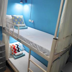 a bunk bed in a room with a blue wall at Crossroads Hostel Manila in Manila