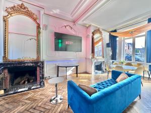 a living room with a blue couch and a fireplace at MONACO Style Jungle - Tourcoing 01 in Tourcoing