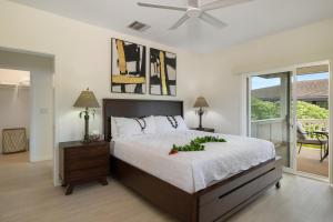 a bedroom with a bed with a flower arrangement on it at Coconut Plantation 1078-3 in Kapolei +37 photos