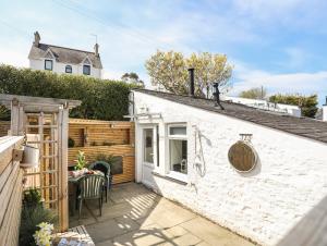 a white house with a patio with a table at Lle Te in Abersoch