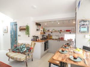 a kitchen with a wooden table and a dining room at Lle Te in Abersoch