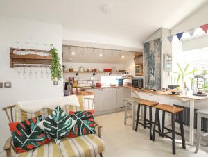 a kitchen with white cabinets and a table and chairs at Lle Te in Abersoch +22 photos