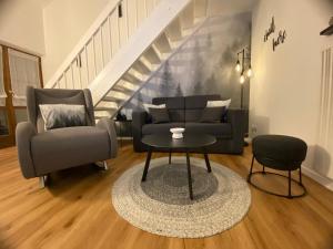 a living room with a couch and a chair and a table at Ferienwohnung Waldstubn in Waldkirchen