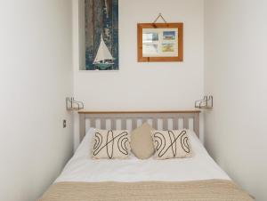 a bedroom with a bed with two pillows on it at Lle Te in Abersoch