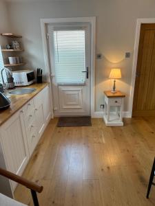 a kitchen with a sink and a table with a lamp at The Old Wash House in Lytham St Annes