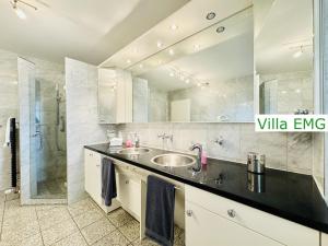 a bathroom with two sinks and a glass shower at Villa EMG Gelsenkirchen Essen Dortmund - Gelsenkirchen in Gelsenkirchen