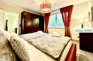 a bedroom with a large bed with red curtains at Villa EMG Gelsenkirchen Essen Dortmund - Gelsenkirchen in Gelsenkirchen