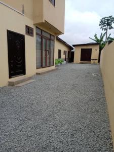 an empty parking lot in front of a building at Alpha Rooms Single Bedroom Gome Fortress Business Center Dansoman Accra in Accra