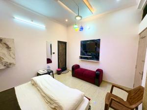 Una televisión o centro de entretenimiento en Shri Radhe Radhe Guest House In-front of Ram Janam Bhumi Main Gate Opposite 200 Meter Fully AC All Rooms