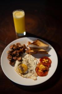 a plate of breakfast food with a glass of orange juice at The Ledge by Bloobuck in Pīrmed +11 photos