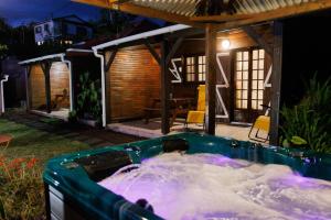 a hot tub in front of a house at night at Bras Lontan in Le Tampon