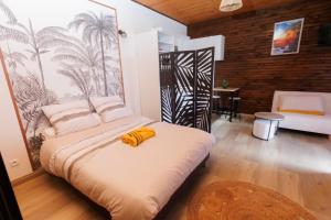 a bedroom with a bed with a yellow object on it at Bras Lontan in Le Tampon