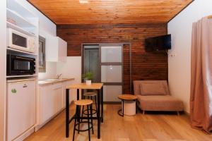 a small kitchen with a table and a chair at Bras Lontan in Le Tampon +26 photos