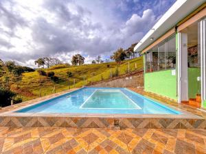 a swimming pool in front of a house at Refúgio nas montanhas em Extrema com cachoeira in Extrema