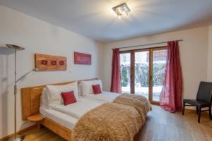 a bedroom with a bed and a window at Lodge 3 Nordic Bath & Garden in Champéry
