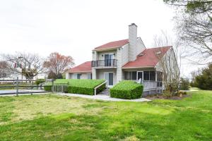 a white house with a red roof and green grass at Countryside Retreat - Fire Pit, Pool, Movie & Game Room in Lottsburg