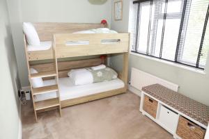 a small room with two bunk beds and a bench at Hassocks Hideaway with Parking Garden in Hassocks +15 photos