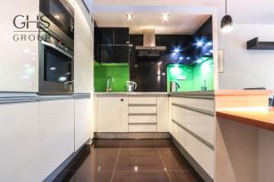 a kitchen with white cabinets and green accents at Beautiful apartment in the city center, Angel City in Kraków