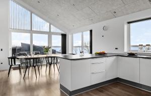 a kitchen with white cabinets and a table with chairs at 3 Bedroom Stunning Home In Aabenraa in Aabenraa