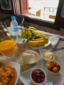 a table topped with plates of food and fruit at Kasbah Nights Retreat and best breakfast offers - Entire House in Tangier +27 photos