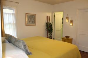 a bedroom with a bed with a yellow blanket at Oldfield Escape in Decatur