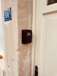 a black clock on the side of a building at La Cigogne in Châteauvillain
