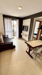 a living room with a bed and a table at Verdes Pássaros Apart Hotel in Florianópolis