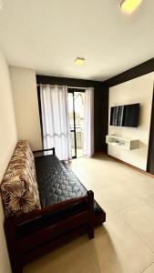 a bedroom with a bed and a flat screen tv at Verdes Pássaros Apart Hotel in Florianópolis