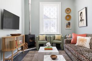a living room with a couch and a tv at Petit Pineapple House in Cape Town