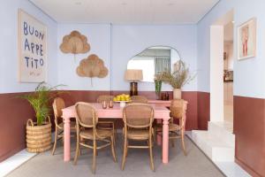 a dining room with a pink table and chairs at Petit Pineapple House in Cape Town