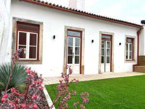 a white house with windows and green grass at Casas de Alpedide in Coimbra