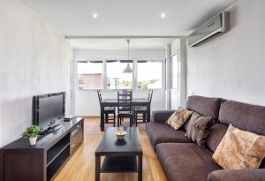 a living room with a couch and a table at Apto en la playa a 20 min en tren de Barcelona in Cabrera de Mar