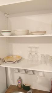 a white shelf with dishes and plates on it at Excellent Studio au cœur historique de Fréjus in Fréjus +16 photos