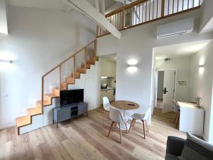 a living room with a staircase and a table and chairs at Casas de Alpedide in Coimbra