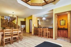 a dining room and kitchen with yellow walls and wooden floors at La Casa De Anta in Asturianos