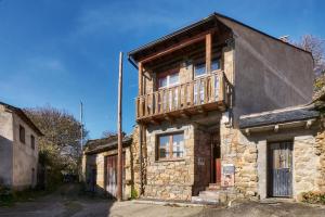 an old stone house with a balcony on top of it at La Casa De Anta in Asturianos