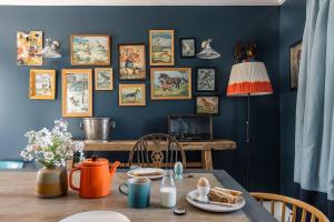 a dining room with a table and a wall of pictures at Cuttieshillock in Banchory