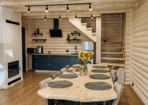 a dining room with a table and a kitchen at SVOI Chalet in Vyshka