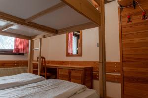 a bedroom with a bed and a wooden desk at Old House - Krvavec ski resort in Cerklje na Gorenjskem