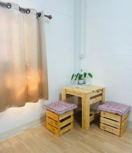 a room with a table and two stools next to a table and a table at Chiangmai homestay in Chiang Mai