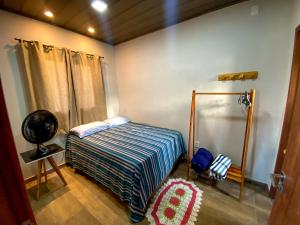 a bedroom with a bed with a striped comforter at Mirante dos Ventos in Luis Correia