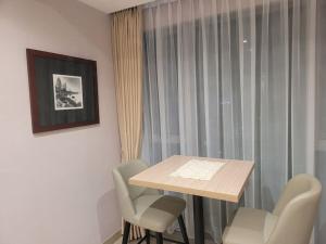 当格浪Homey 1 BR Apt at Branz BSD的有窗户的房间里有一张桌子和几把椅子 更多10张照片