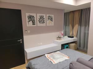 当格浪Homey 1 BR Apt at Branz BSD的一间卧室配有一张床,窗户配有绘画作品