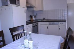 una cocina con una mesa con botellas y vasos. en Rungholtstrasse Bungalow, en Wyk auf Föhr