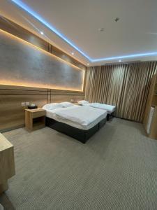 a hotel room with two beds in a room with avertisementvertisement at رامة المدينة للشقق المخدومة in Sīdī Ḩamzah +26 photos