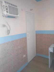 a room with a door and a fan on the wall at Three C’s Beach Resort in Dingalan