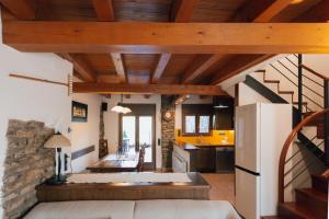a large kitchen with wooden ceilings and a white refrigerator at Ca l'Andreu in Ribera de Montardit