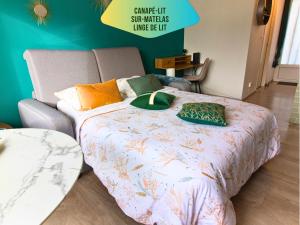 a bed with pillows on it in a room at Le Pic'Vert - Escapade Solo ou Duo - Hôpital à 400m - Parking gratuit - GARE & CENTRE HISTORIQUE 15min à pied - Clim - Balcon au calme in Bergerac +26 photos