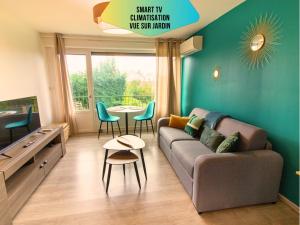 a living room with a couch and a table at Le Pic'Vert - Ideal couples & professionals - FREE Parking - 400m Hospital - 15min Train station & HISTORIC Center - Air conditionner - Calm & Cosy in Bergerac